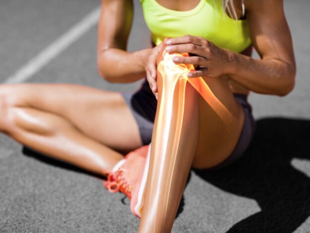 Low section of sportswoman suffering from knee pain